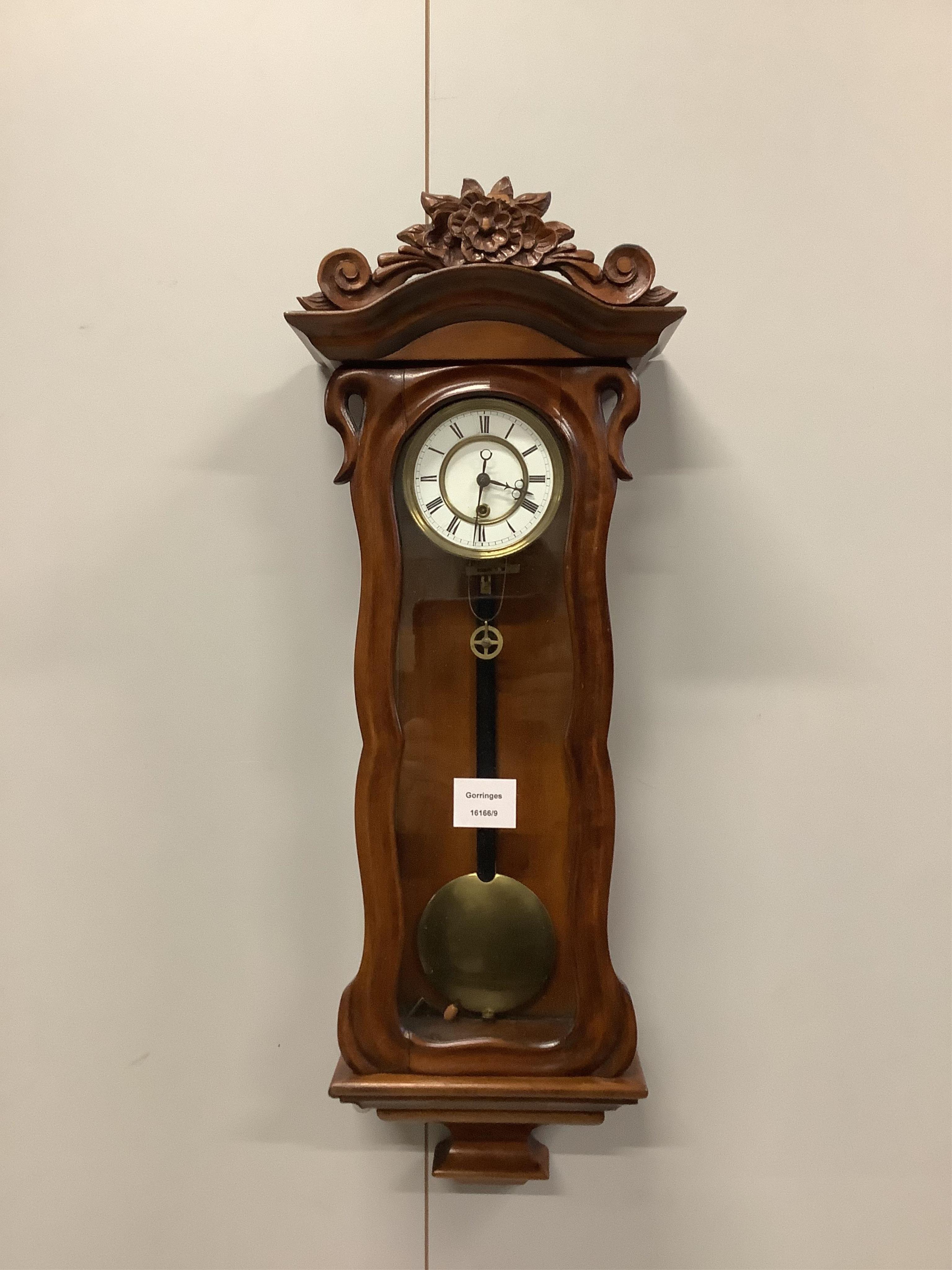 A small late 19th century carved glazed mahogany eight day Vienna style wall clock, height 64cm. Condition - good